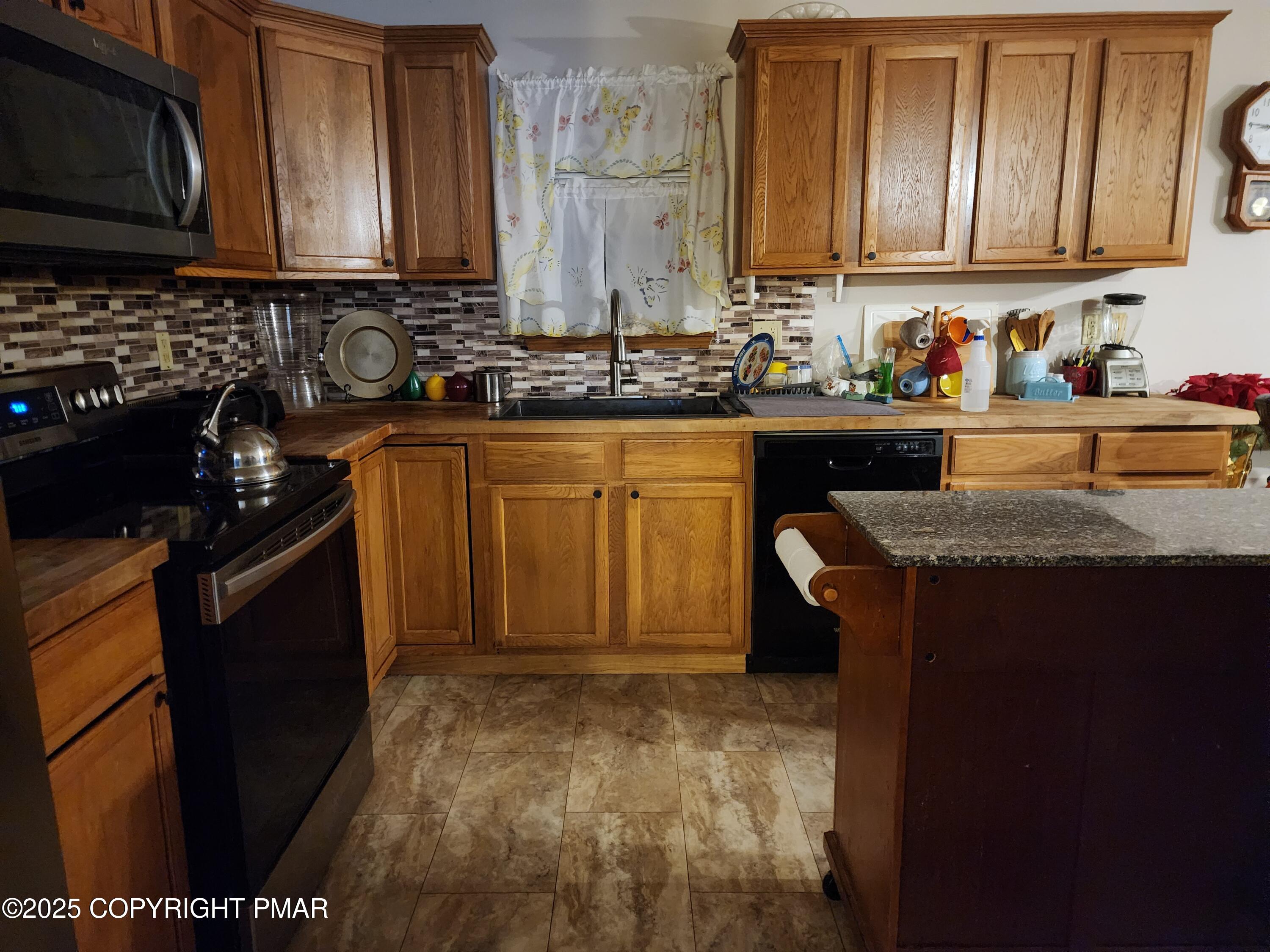 195 Williams Lane Scotrun, PA 18355 - Photo 9 of 17 a kitchen with granite countertop cabinets and black appliances