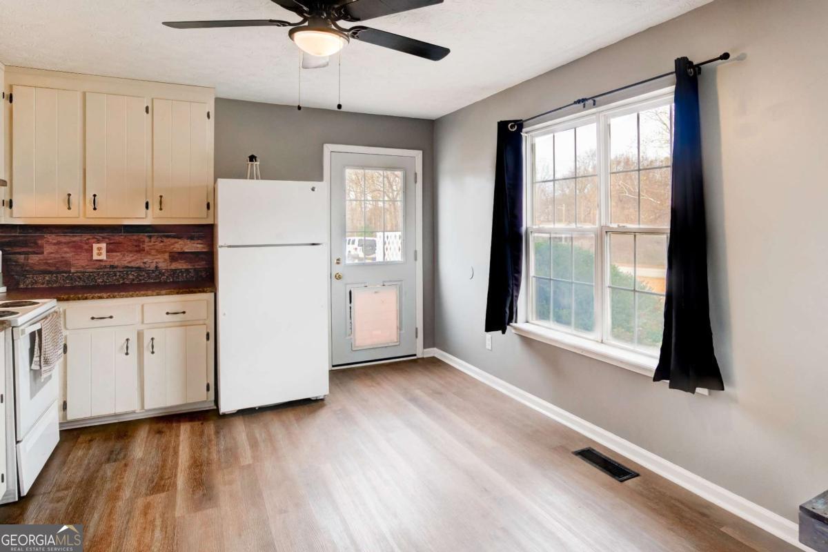 665 Caney Branch Road Lavonia, GA 30553 - Photo 16 of 26 a kitchen with a refrigerator and white cabinets