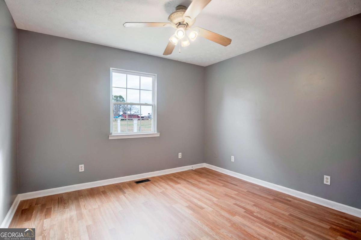 665 Caney Branch Road Lavonia, GA 30553 - Photo 19 of 26 a view of an empty room with window and wooden floor