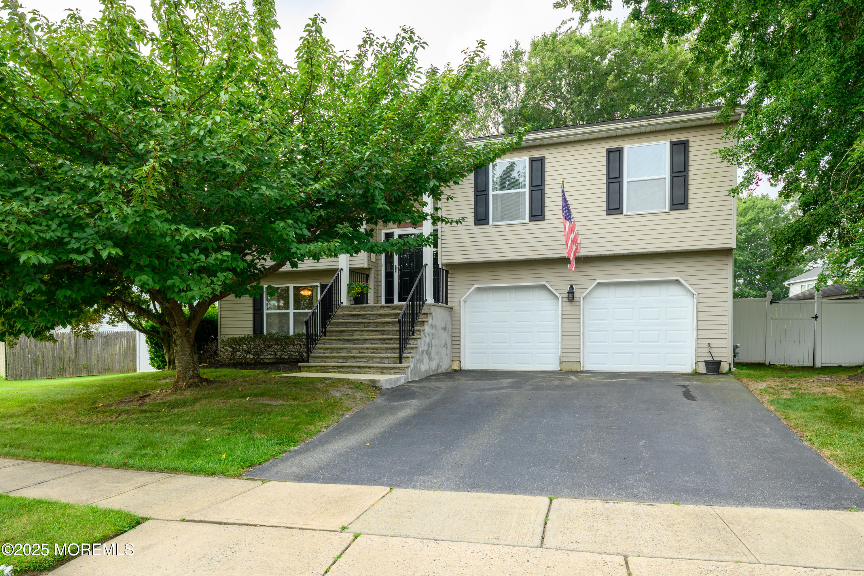 a view of a white house with a big yard and large trees
