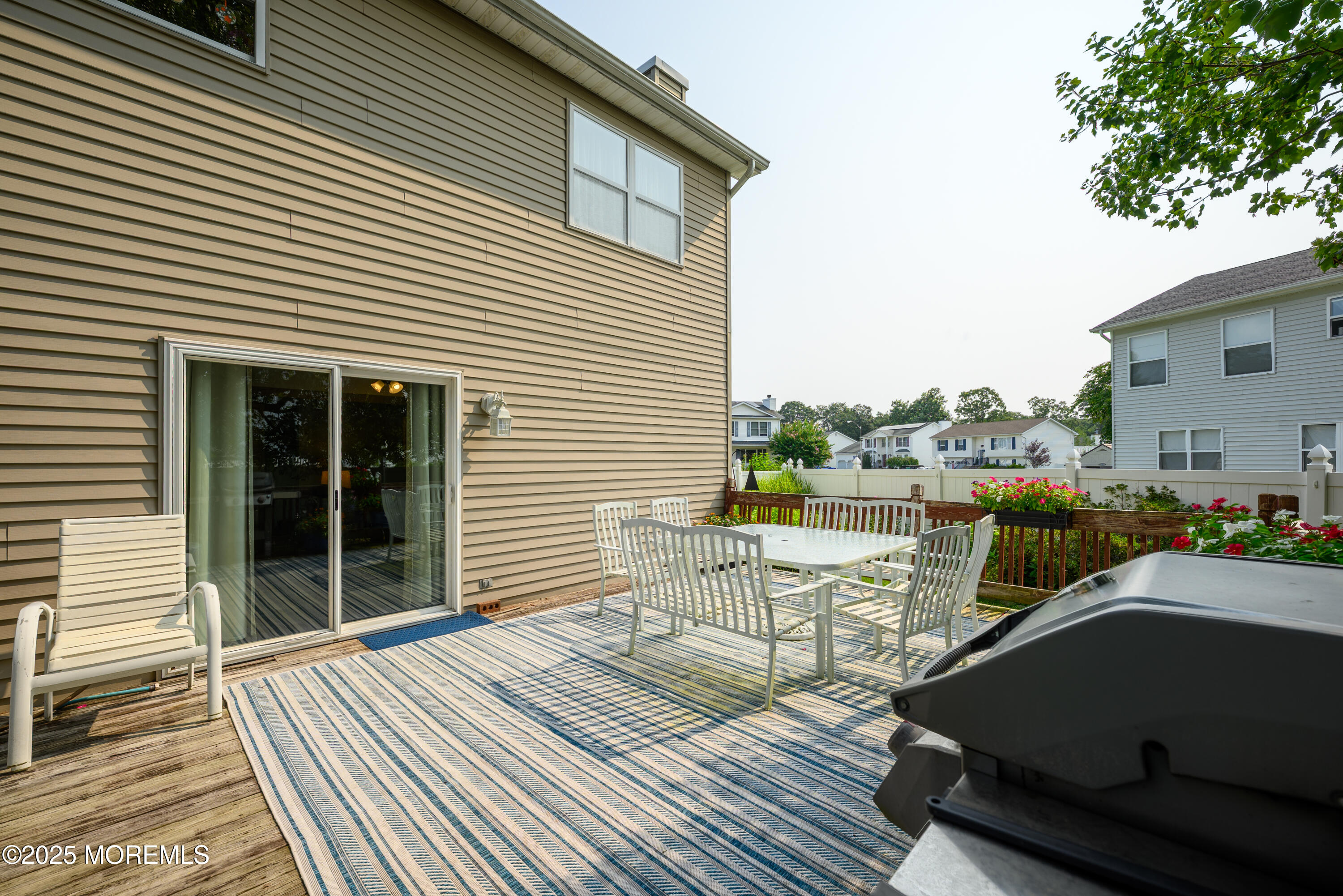 18 Fella Street Howell, NJ 07731 - Photo 26 of 35 a view of a roof deck with table and chairs a barbeque with wooden floor and fence