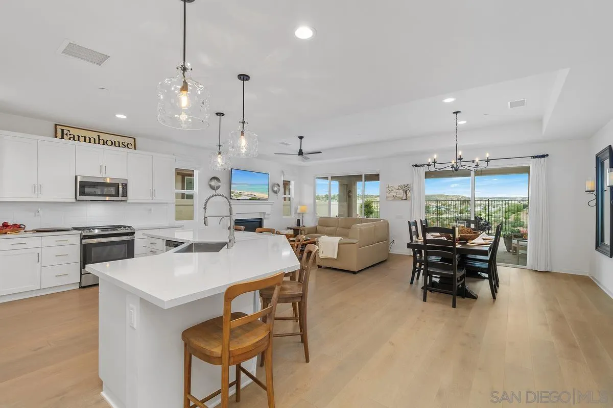 32082 Sedge Way Temecula, CA 92591 - Photo 12 of 59 a open kitchen with stainless steel appliances granite countertop a stove a sink a dining table and chairs with wooden floor