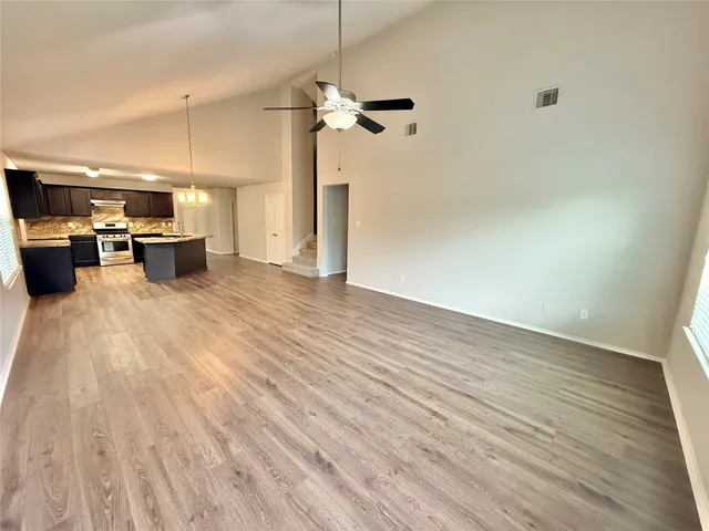 a view of a backyard with plants and large tree