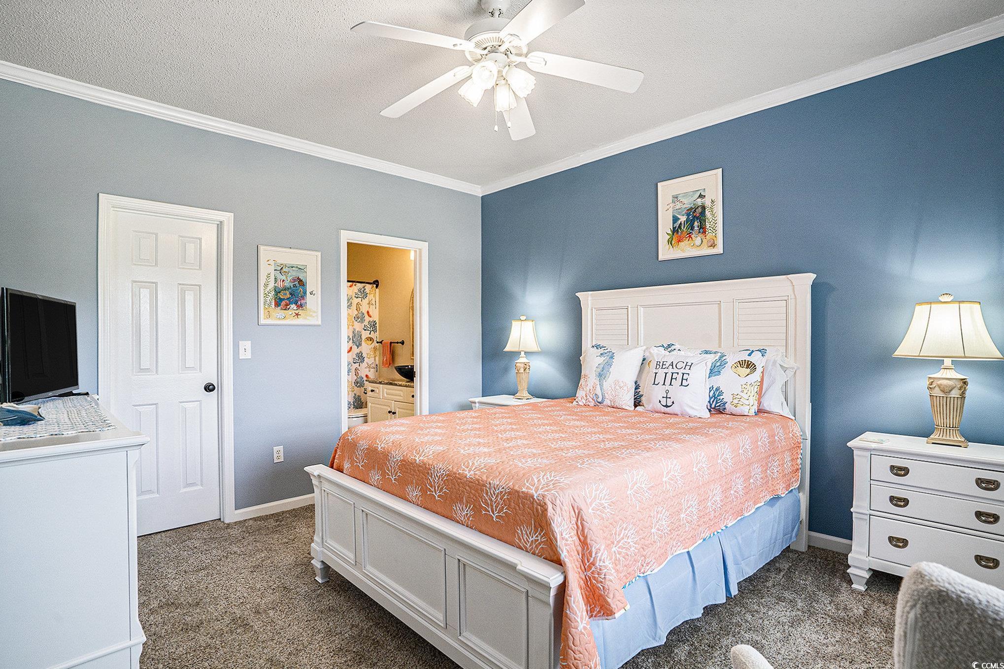 4459 Turtle Lane, Unit 3D Little River, SC 29566 - Photo 14 of 30 Bedroom featuring ornamental molding, dark colored carpet, ensuite bath, and a ceiling fan