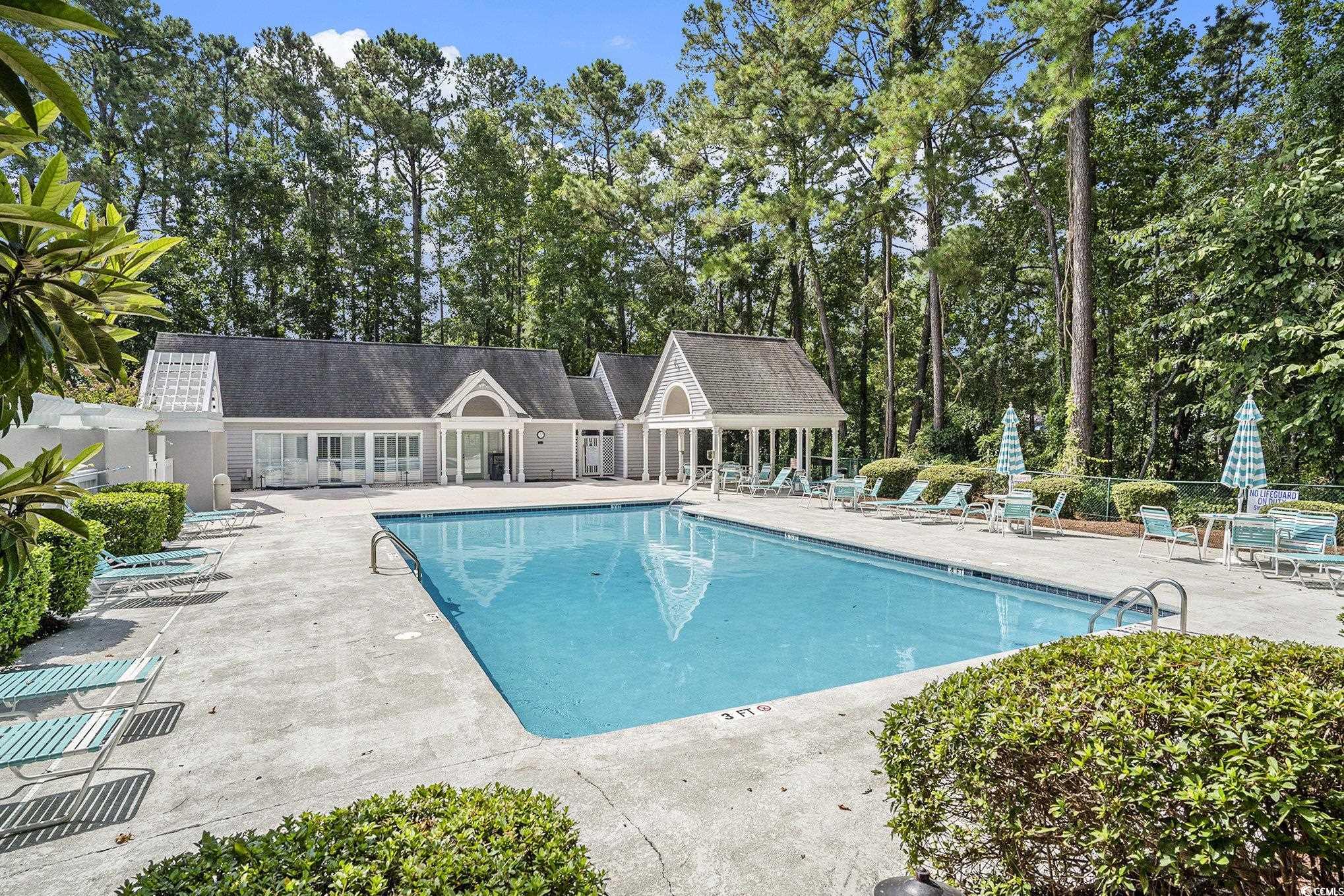 4459 Turtle Lane, Unit 3D Little River, SC 29566 - Photo 30 of 30 Community pool with a patio area and view of scattered trees