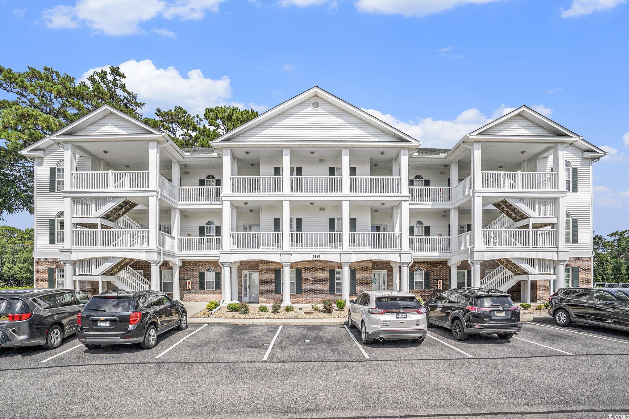 4459 Turtle Lane, Unit 3D Little River, SC 29566 - Photo 3 of 30 View of building exterior featuring uncovered parking and stairway