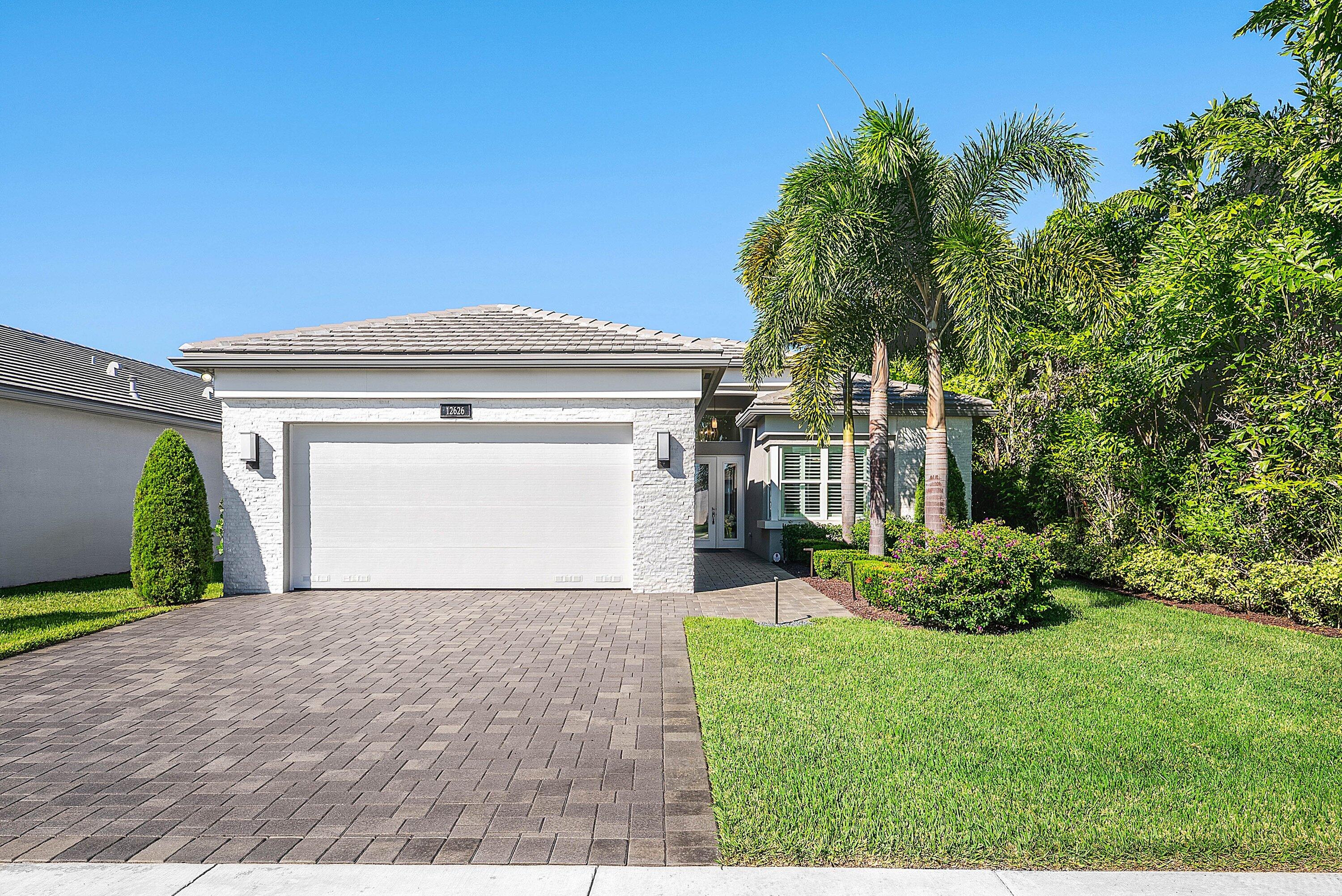 12626 Parrot Pond Road Boynton Beach, FL 33473 - Photo 1 of 67 a view of a house with a small yard and a garden