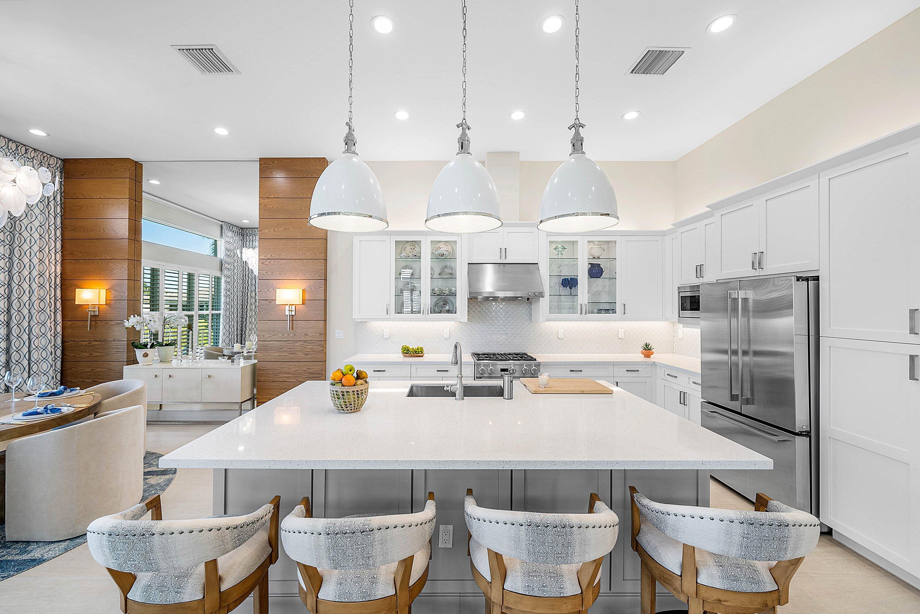 12626 Parrot Pond Road Boynton Beach, FL 33473 - Photo 13 of 67 a kitchen with stainless steel appliances a dining table chairs and a refrigerator