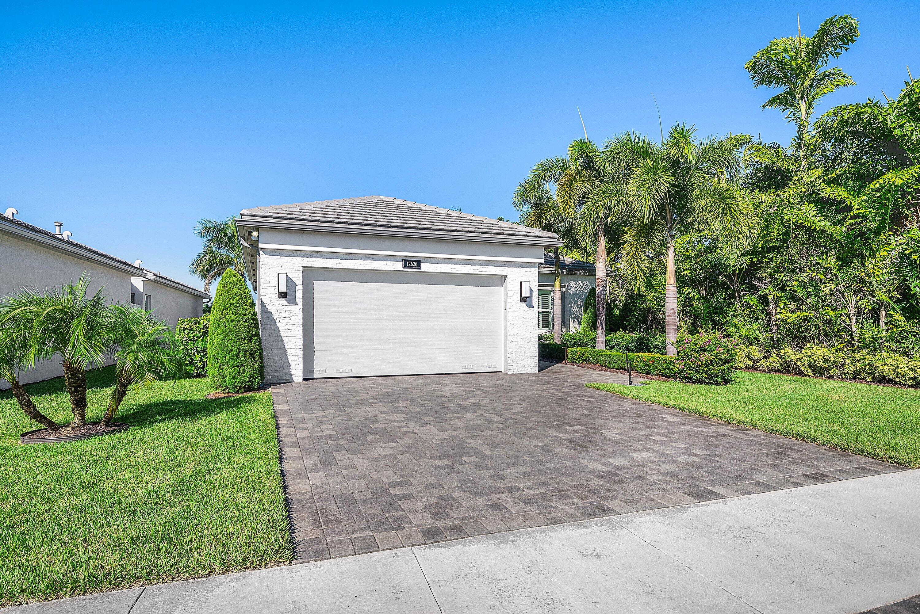 12626 Parrot Pond Road Boynton Beach, FL 33473 - Photo 2 of 67 a front view of a house with a yard and garage
