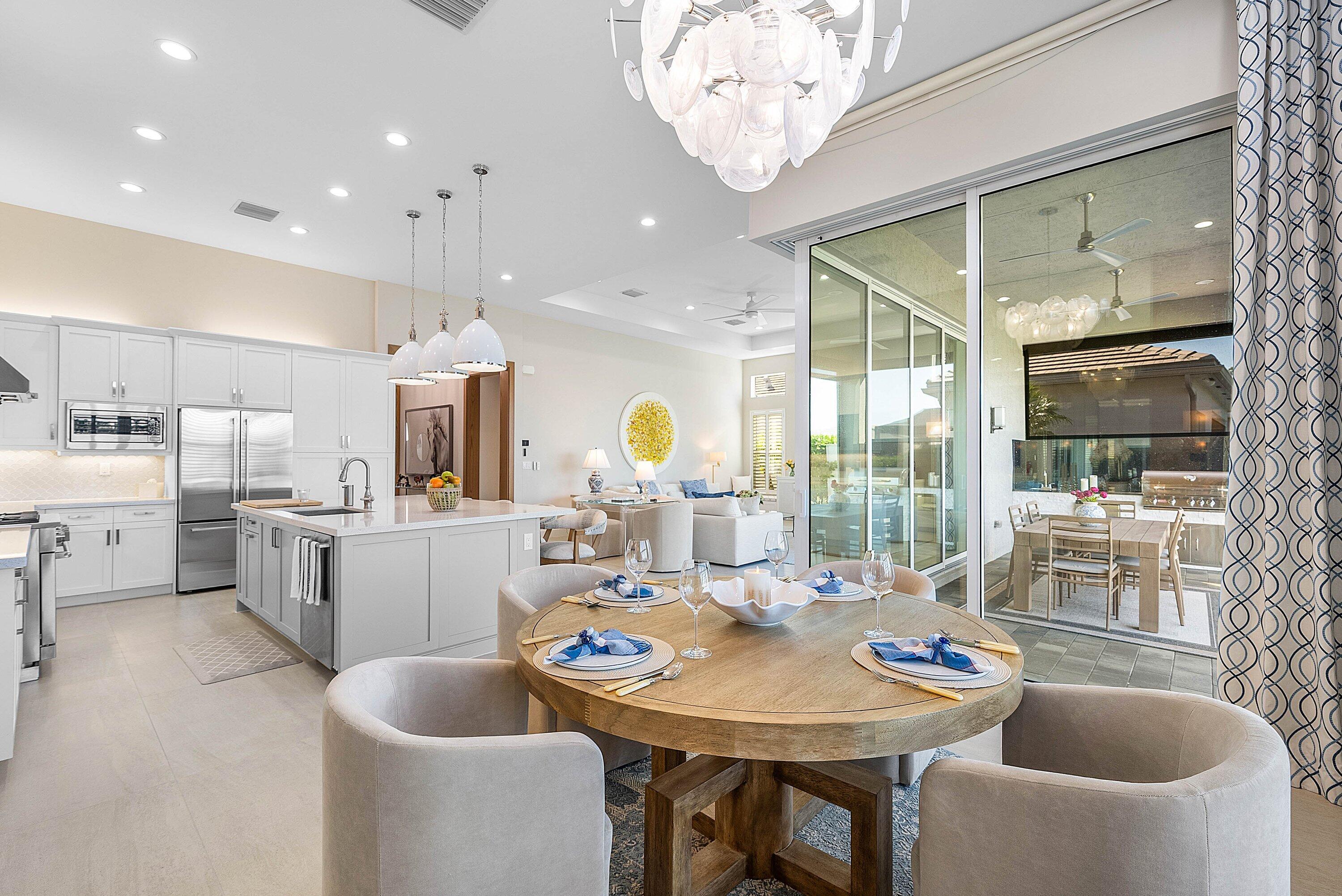 12626 Parrot Pond Road Boynton Beach, FL 33473 - Photo 21 of 67 a dining room with kitchen island stainless steel appliances furniture a chandelier a large window and kitchen view