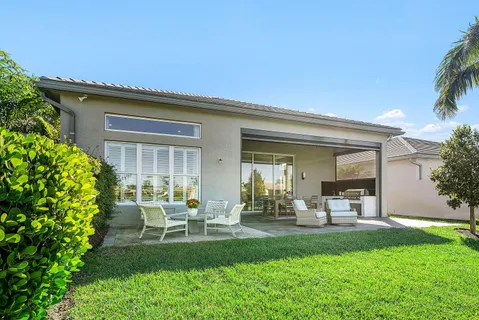 a view of a house with a yard and potted plants