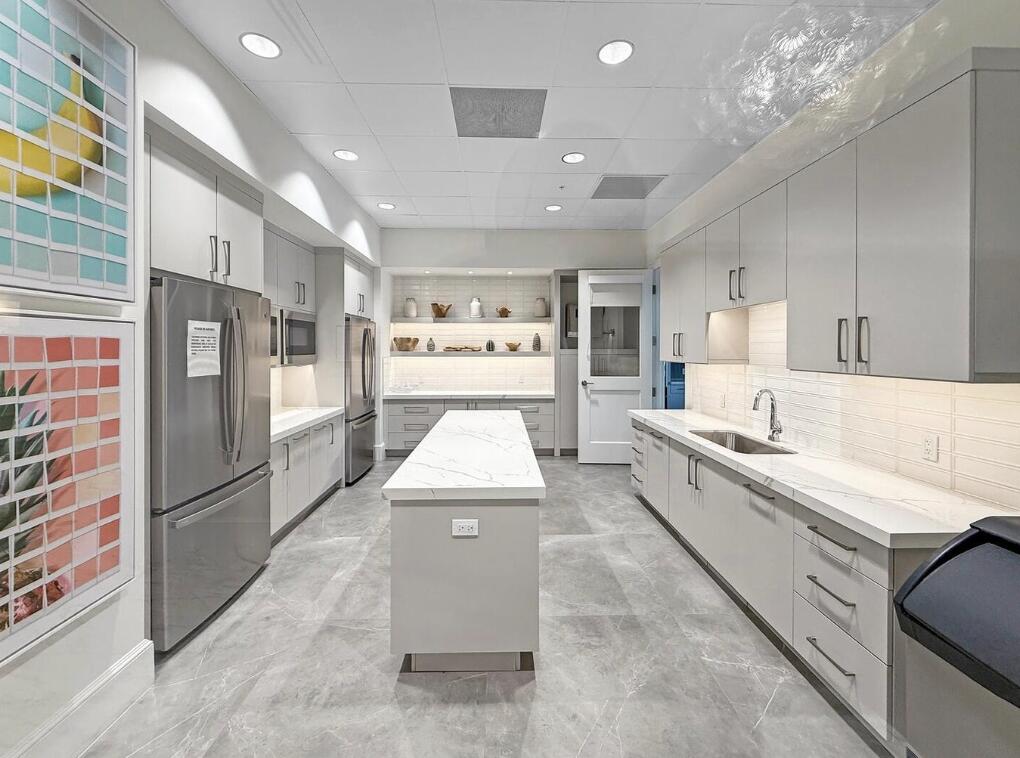 12626 Parrot Pond Road Boynton Beach, FL 33473 - Photo 63 of 67 a large kitchen with stainless steel appliances kitchen island granite countertop a refrigerator and a sink