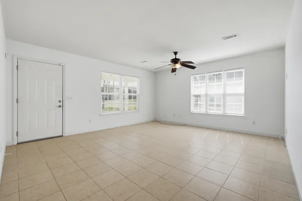 an empty room with windows and chandelier