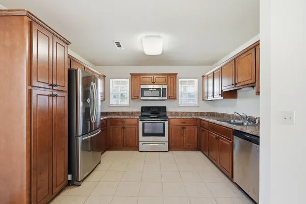 a kitchen with stainless steel appliances granite countertop a refrigerator sink and stove