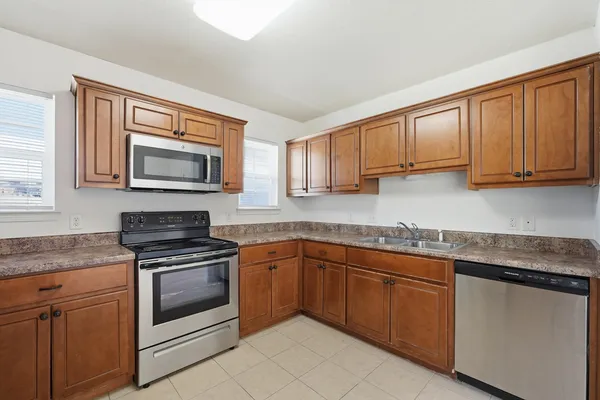 a kitchen with stainless steel appliances granite countertop a sink a stove with cabinets