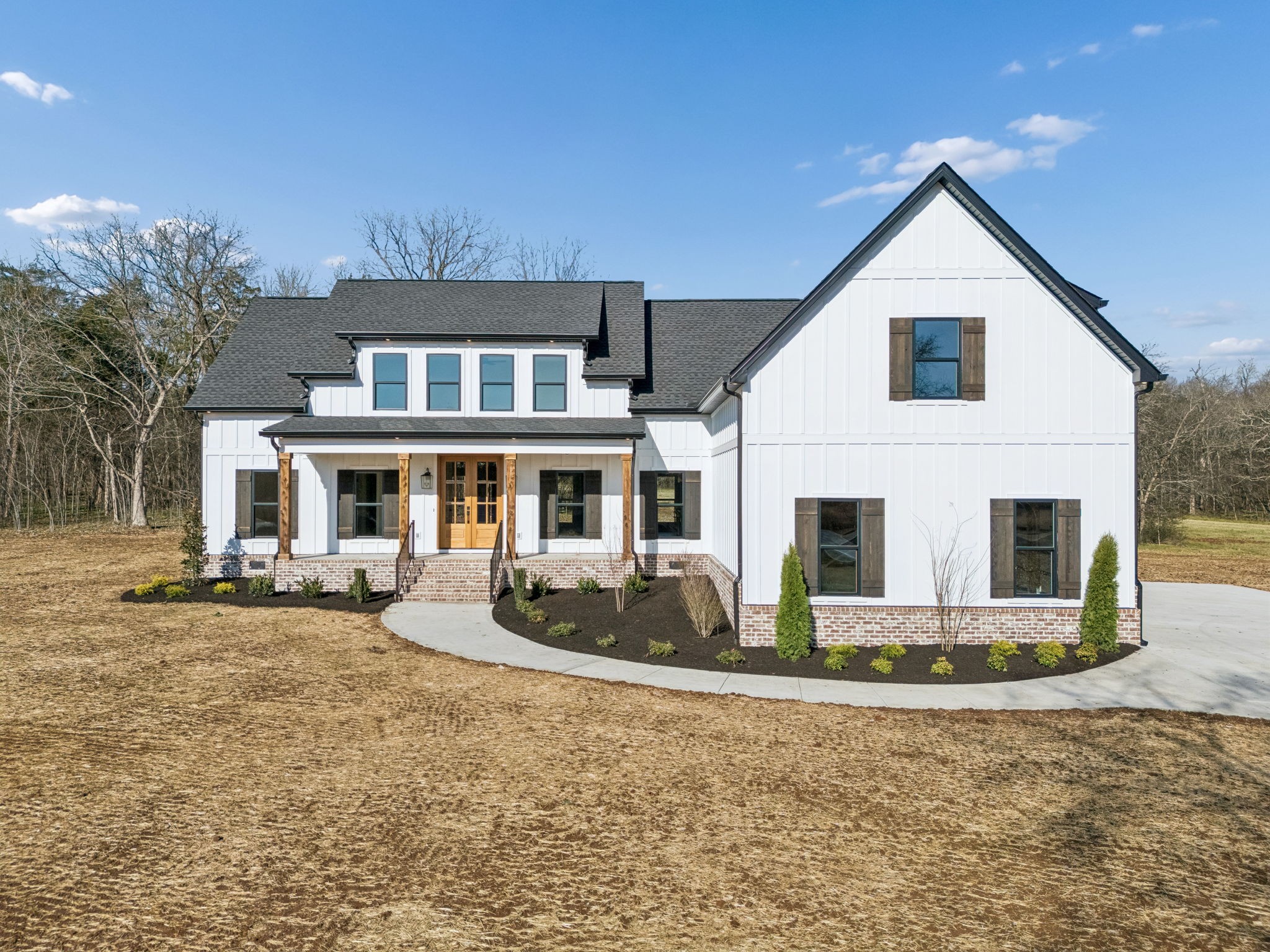 a front view of a house with yard and parking