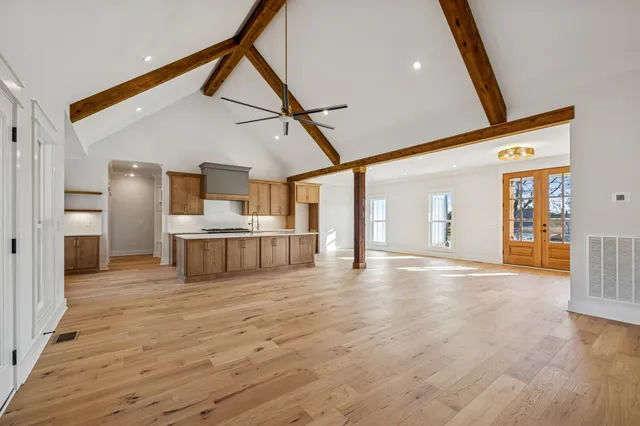a view of empty room with wooden floor and ceiling fan