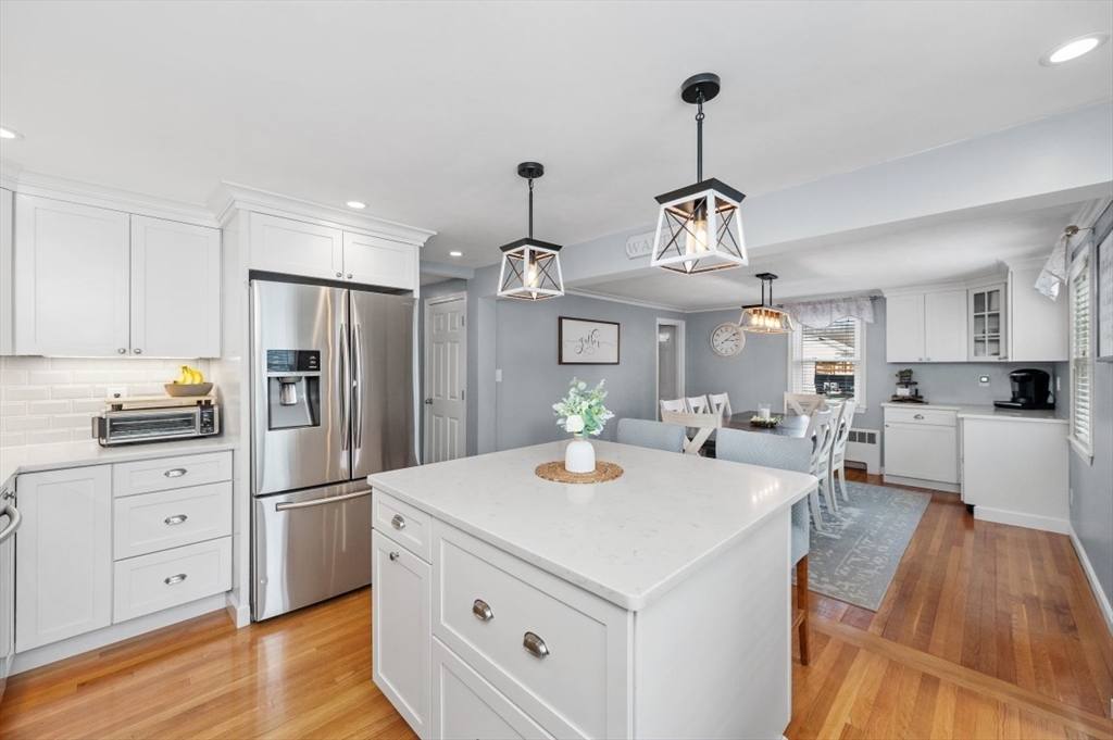 10 Shade Street Waltham, MA 02452 - Photo 4 of 33 a kitchen with refrigerator a stove and white cabinets