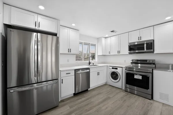 a kitchen with stainless steel appliances a refrigerator stove and microwave