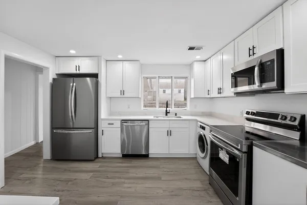 a kitchen with stainless steel appliances a refrigerator sink and microwave