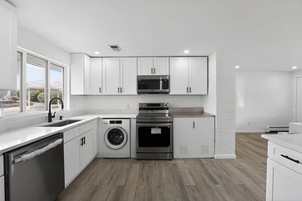 a kitchen with a stove a sink and a microwave