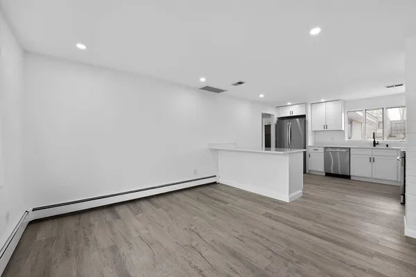 a view of a kitchen with wooden floor and electronic appliances
