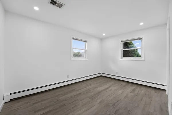 an empty room with a hardwood and ceiling fan