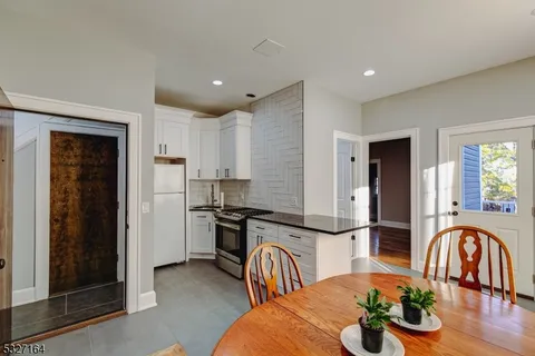 a kitchen with stainless steel appliances granite countertop a dining table and chairs