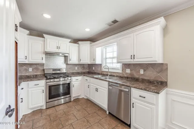 a kitchen with stainless steel appliances granite countertop a refrigerator and a sink