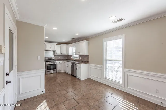 a kitchen with stainless steel appliances granite countertop a stove a sink and a refrigerator