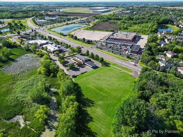 an aerial view of residential houses with outdoor space and parking