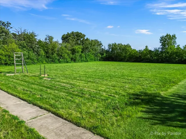 a view of a green field with wooden fence
