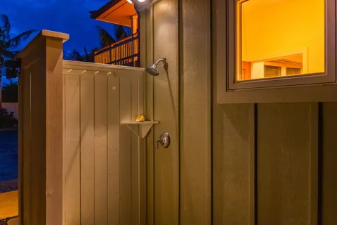 a spacious bedroom with a large bed a chandelier and windows