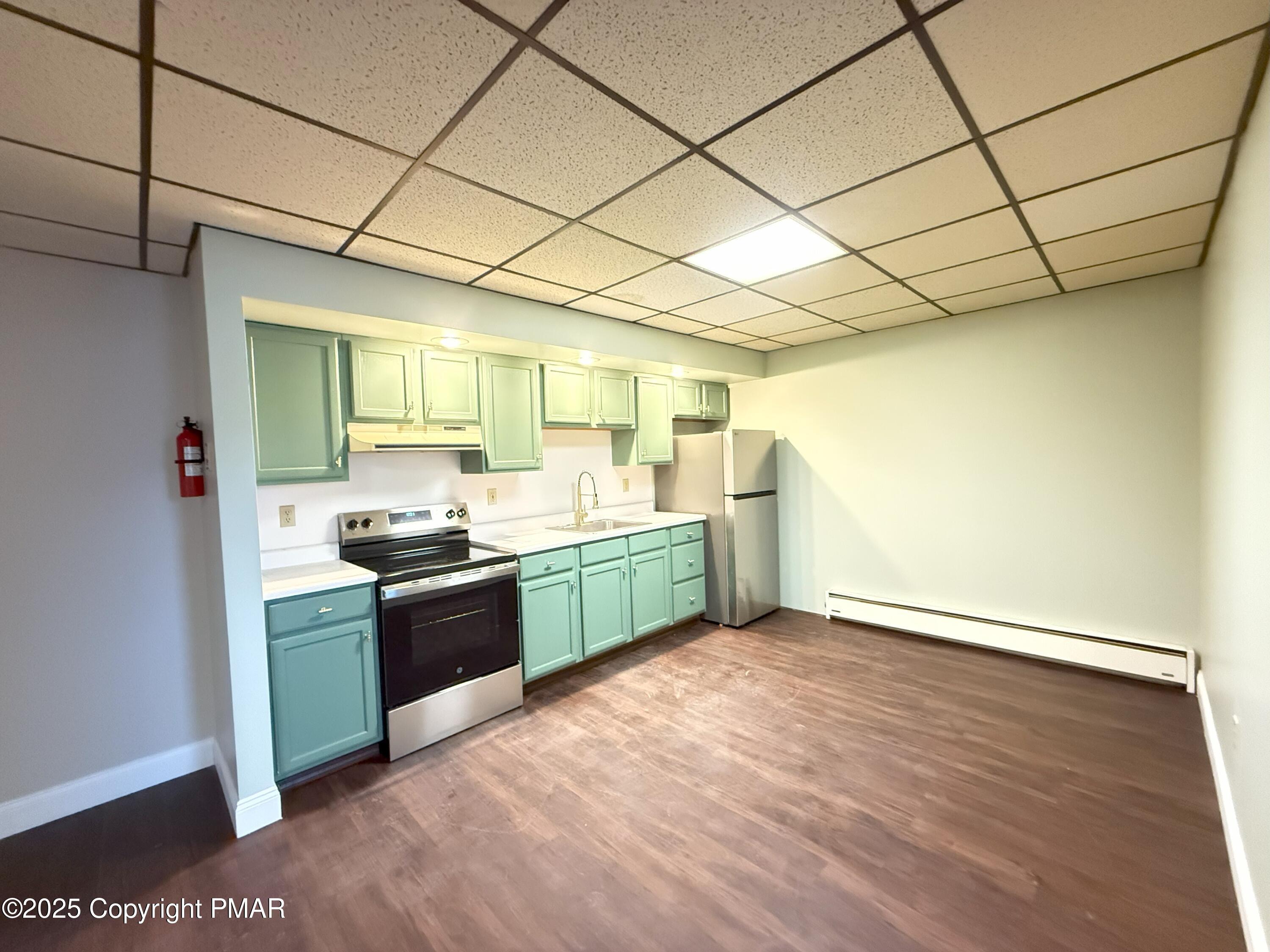 a kitchen with stainless steel appliances granite countertop a sink a stove top oven and wooden floor