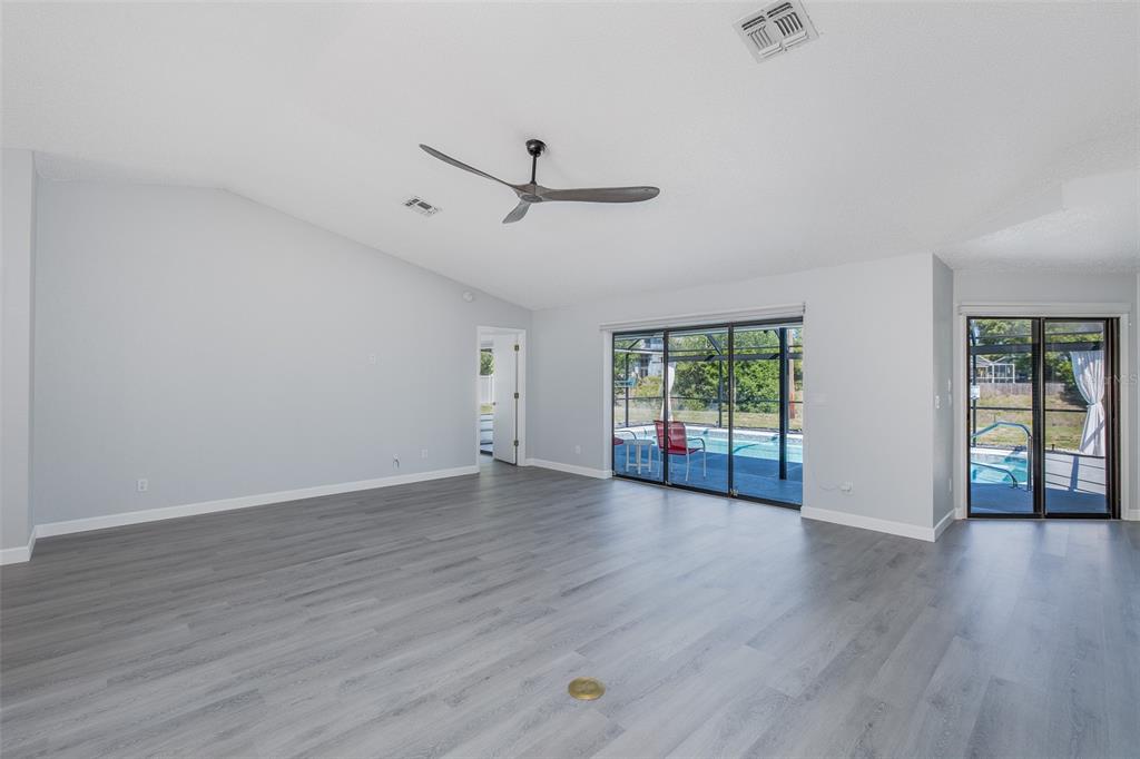 8285 Galgano Lane Spring Hill, FL 34606 - Photo 11 of 55 a view of an empty room with wooden floor and a window