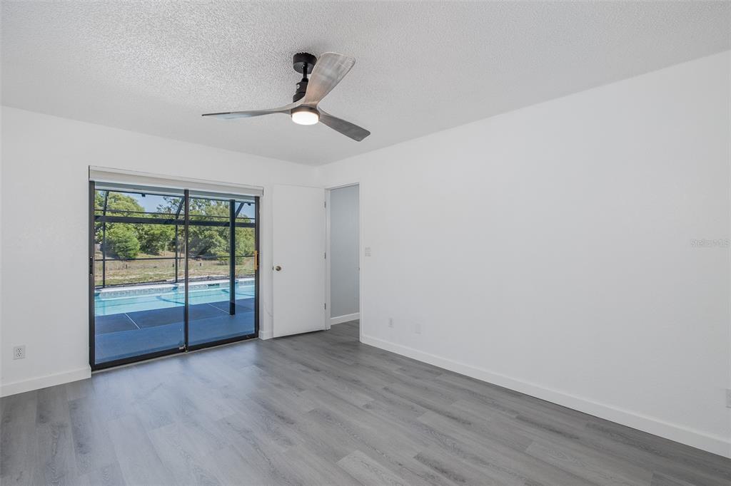 8285 Galgano Lane Spring Hill, FL 34606 - Photo 22 of 55 a view of an empty room with wooden floor and fan
