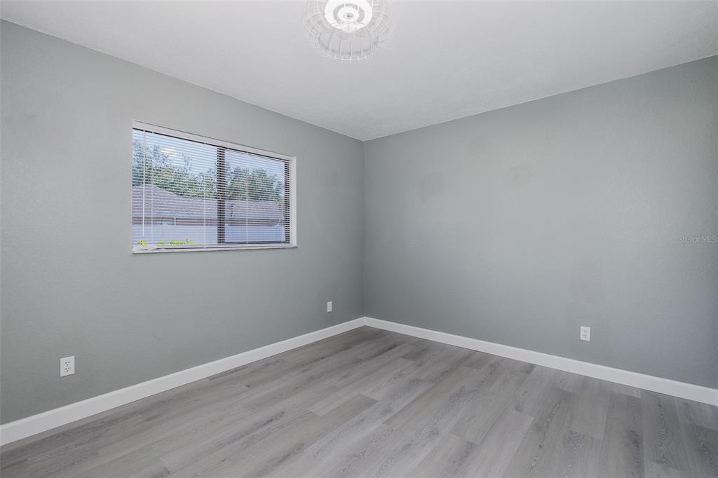 8285 Galgano Lane Spring Hill, FL 34606 - Photo 27 of 55 a view of an empty room with wooden floor and a window