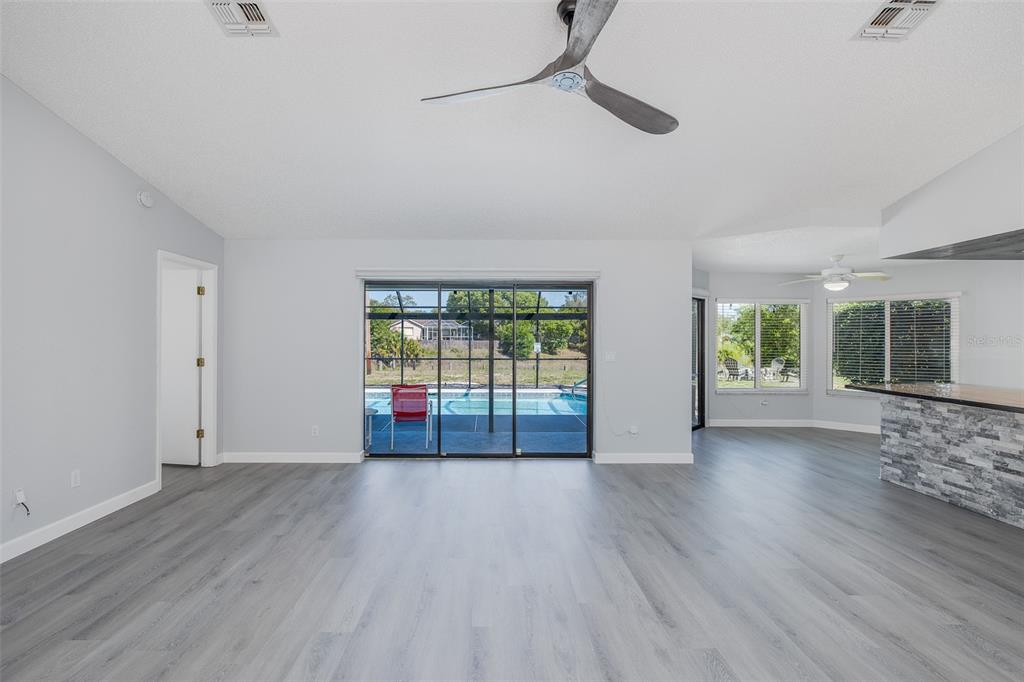 8285 Galgano Lane Spring Hill, FL 34606 - Photo 9 of 55 a view of an empty room with wooden floor and a window