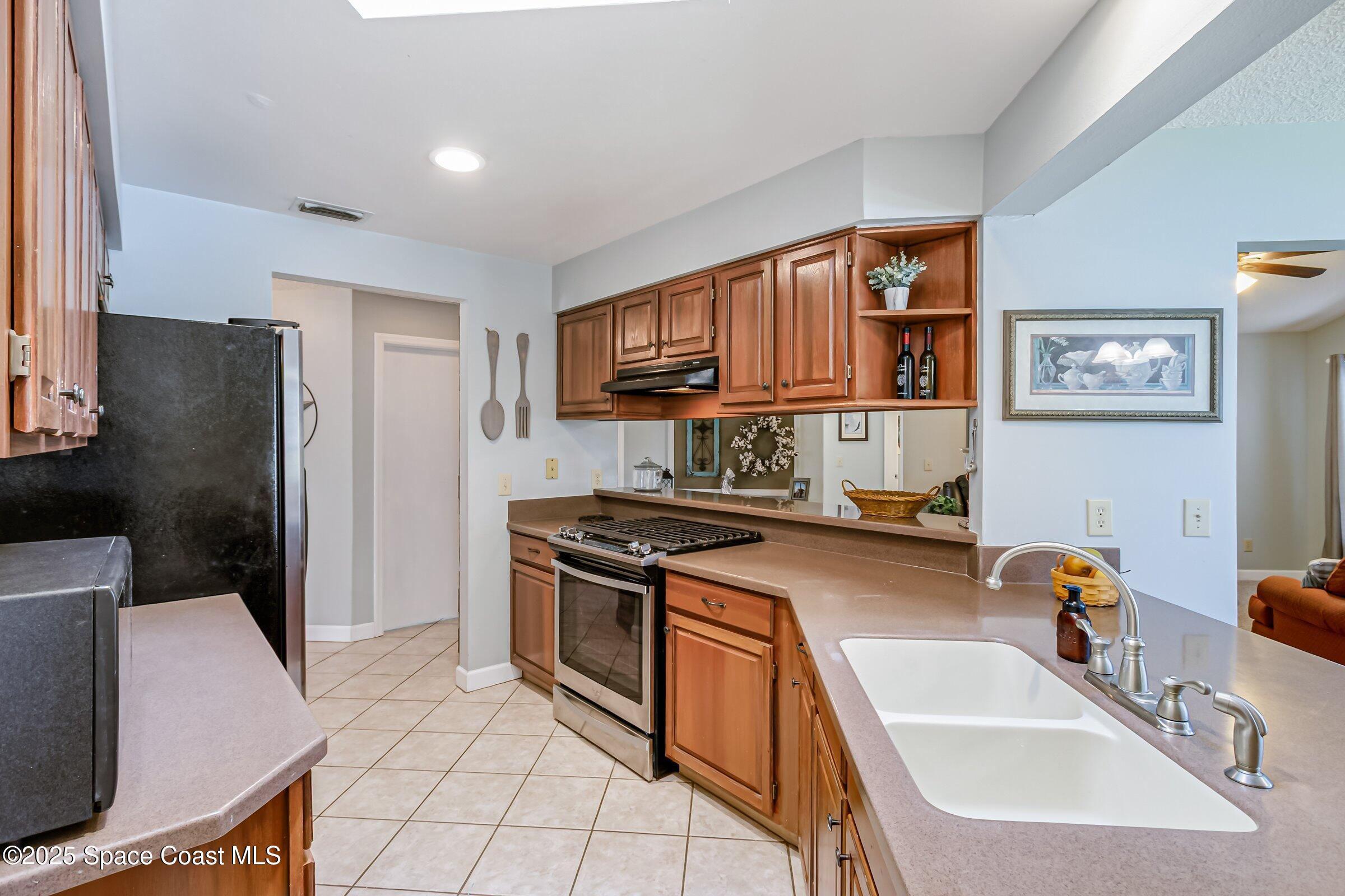 4351 Silver Lake Drive Melbourne, FL 32901 - Photo 19 of 55 a kitchen with stainless steel appliances granite countertop a sink stove and refrigerator
