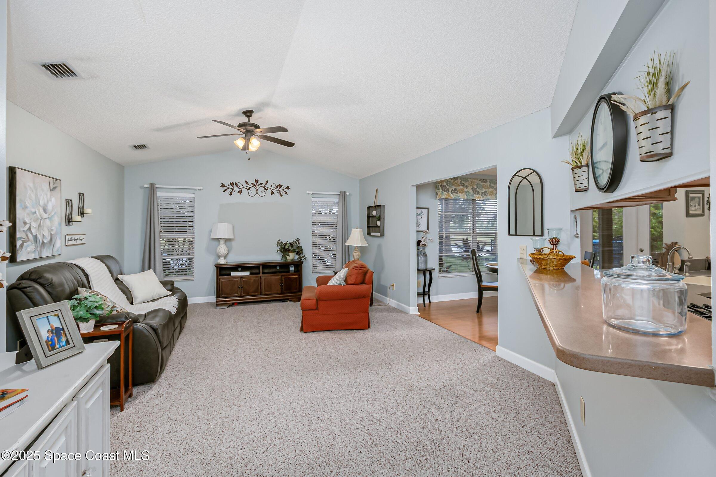4351 Silver Lake Drive Melbourne, FL 32901 - Photo 27 of 55 a living room with furniture and a chandelier