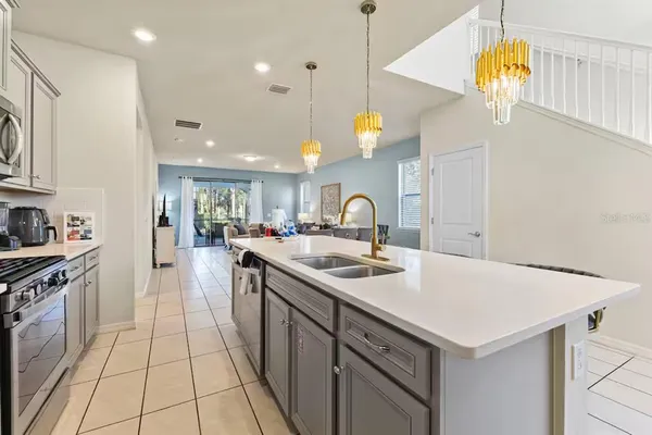 a kitchen with a sink a stove and chairs