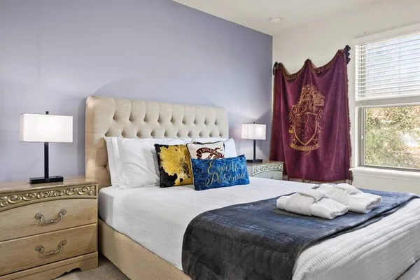 a bedroom with a bed and a lamp on dresser