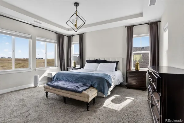 a spacious bedroom with a bed and wooden floor