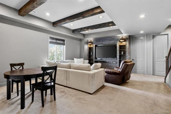 a living room with furniture a flat screen tv and a large window