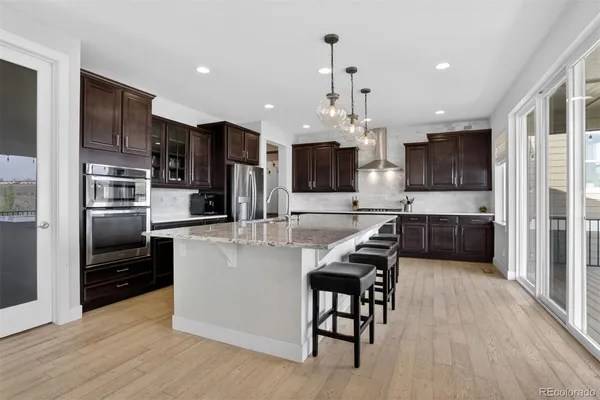 a kitchen with stainless steel appliances kitchen island granite countertop a refrigerator and a stove top oven