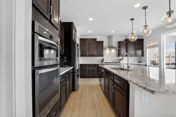 a kitchen with stainless steel appliances granite countertop a sink a stove and a refrigerator