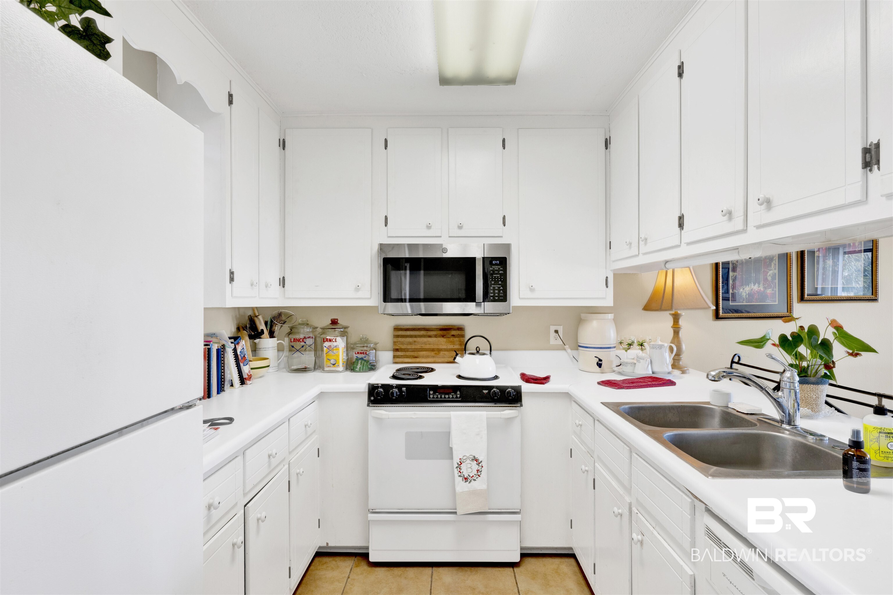 26222 Marina Road Orange Beach, AL 36561 - Photo 20 of 38 Kitchen featuring white appliances, light countertops, white cabinets, and light tile patterned floors