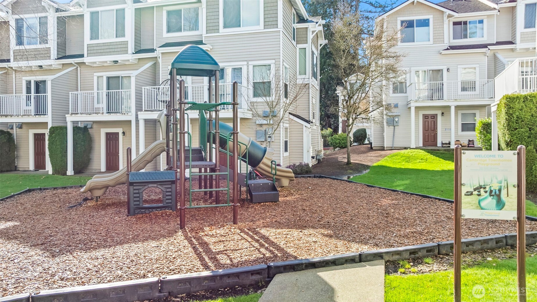 16373 119th Terrace Northeast, Unit 315 Bothell, WA 98011 - Photo 23 of 27 a front view of a house with a garden and chairs
