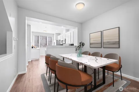 a view of a a dining room with furniture window and wooden floor