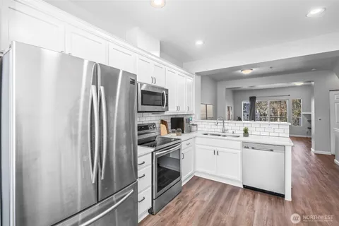 a kitchen with stainless steel appliances a refrigerator sink and microwave